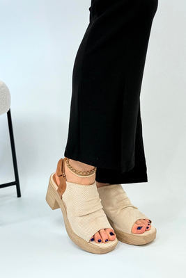 Beżowe sandały zabudowane na drewnianym słupku