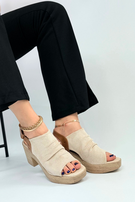 Beżowe sandały zabudowane na drewnianym słupku