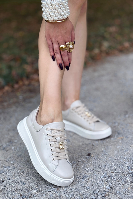 Бежеві шкіряні кросівки на перфорованій танкетці